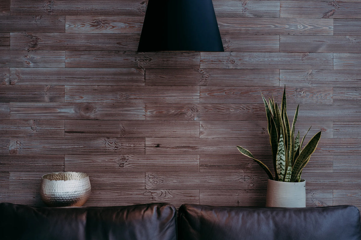 Eine frontale Ansicht der grau-braunen Holzpaneel-Wand, dekoriert mit einer silbernen Schale und einer Bogenhanf-Pflanze in einem schlichten weißen Topf. Die gleichmäßige, horizontale Verlegung der Paneele schafft einen ruhigen und strukturierten Hintergrund.