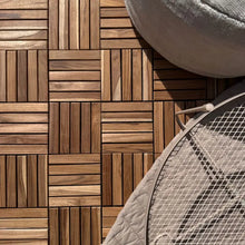 Lade das Bild in den Galerie-Viewer, Holzfliesen aus Teak sind auf dem Boden ausgelegt. Darauf stehen ein Pouf und ein Metalltisch mit einem untergelegten Polster.
