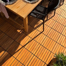 Lade das Bild in den Galerie-Viewer, Eine mit Akazien-Holzfliesen ausgelegte Terrasse, auf der ein gedeckter Tisch steht.
