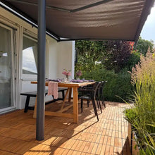 Lade das Bild in den Galerie-Viewer, Eine mit Akazien-Holzfliesen ausgelegte Terrasse, auf der ein gedeckter Tisch steht.
