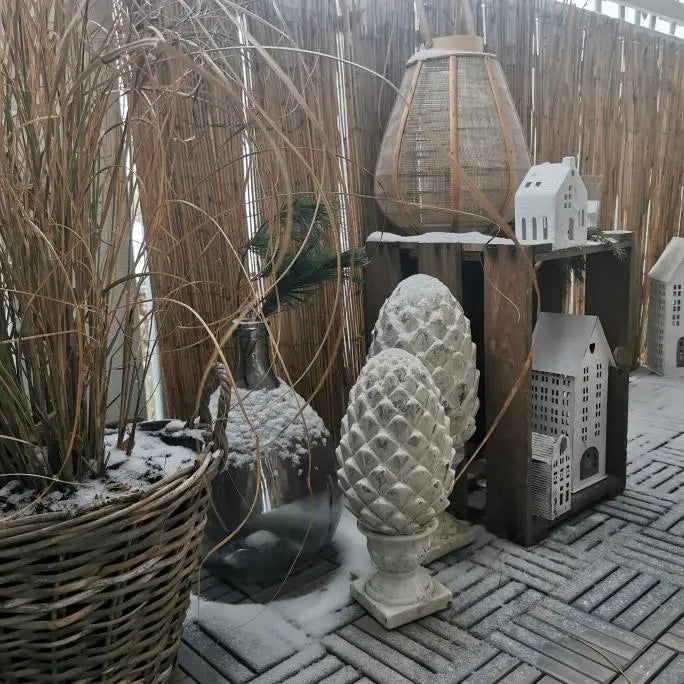 Ein verschneiter Balkon mit grauen Holzfliesen