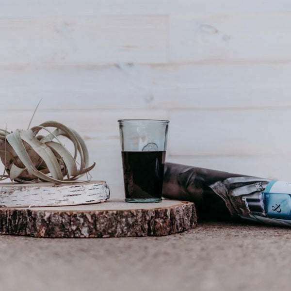 Ein volles Glas steht auf einer Birkenholzscheibe