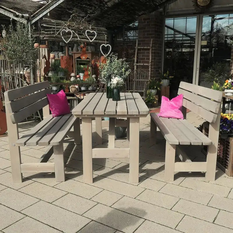 Eine graue Gartengarnitur aus Kiefernholz steht in der Sonne.