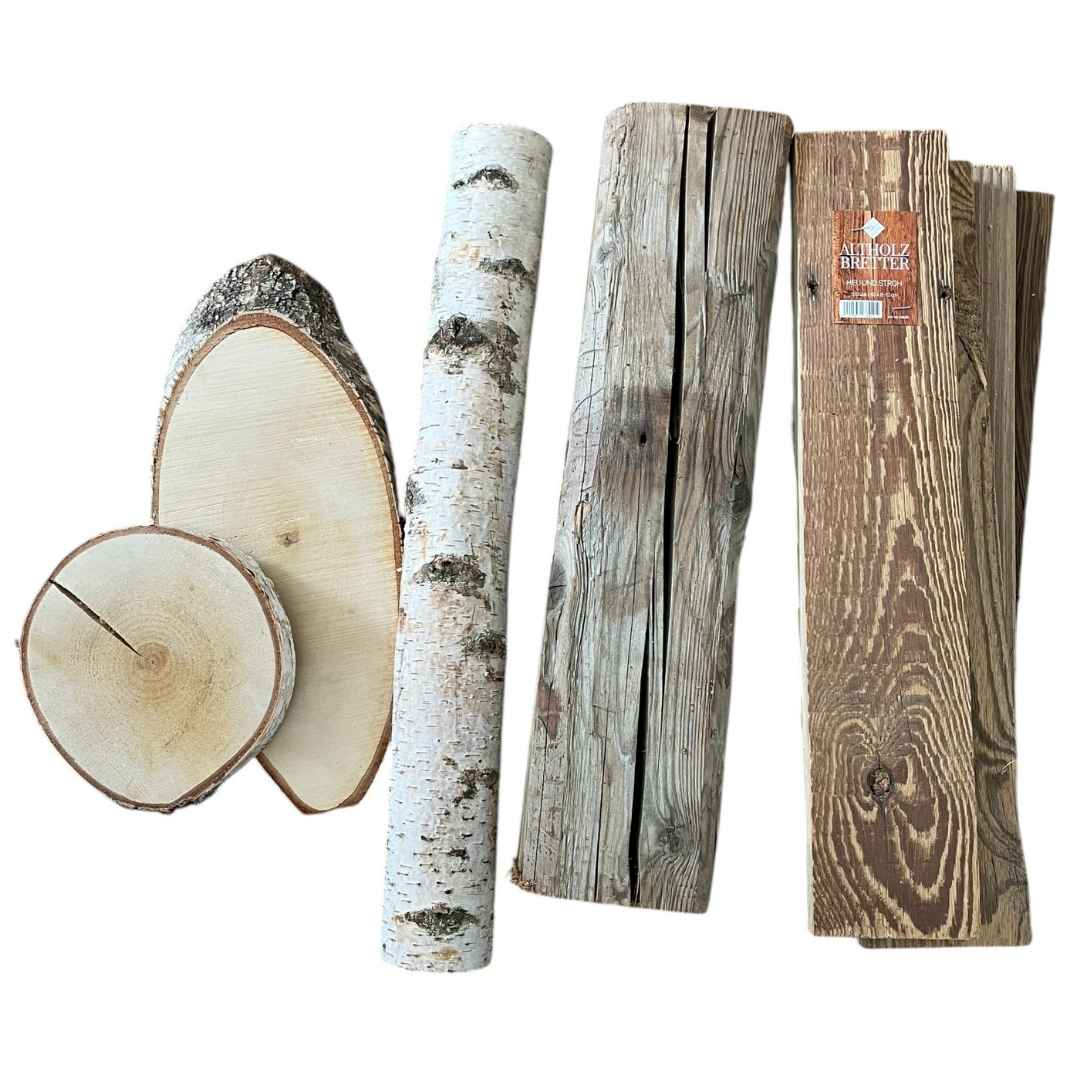 Eine Zusammenstellung verschiedener Holzelemente auf weißem Grund, darunter Baumscheiben mit Rinde, ein Birkenstamm sowie ein rustikaler Altholzbalken und Altholzbretter. Die Anordnung veranschaulicht die Vielfalt der natürlichen Rohmaterialien für die Holzverarbeitung.