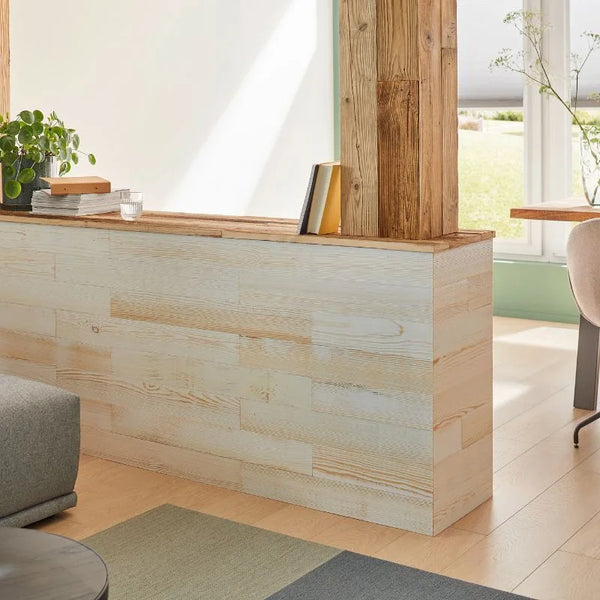 Eine Halbwand mit Holzpaneelen in Weiß und einer Säule, verkleidet mit Altholzbrettern