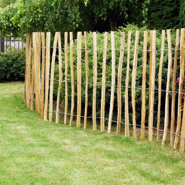 Aufnahme eines in einem Garten platzierten Staketenzauns aus Haselnussholz.