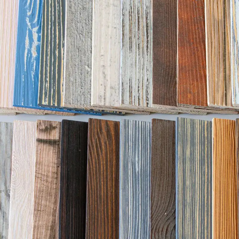 Zahlreiche kleine Holzpaneel-Muster in verschiedenen Farben, Streichungen und Maserungen liegen dicht nebeneinander aufgereiht.