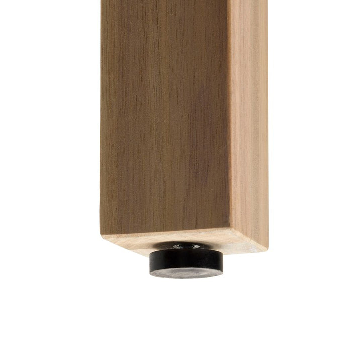 Eine Detailaufnahme eines quadratischen Möbelfußes aus Holz, an dessen Unterseite ein flacher, schwarzer Kunststoffgleiter zum Schutz des Bodens montiert ist.